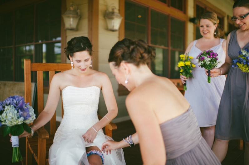 Bride getting garter belt put on 