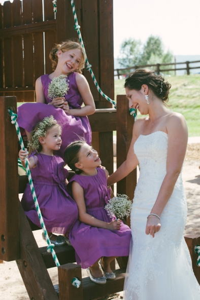 Bride laughing with flower girls