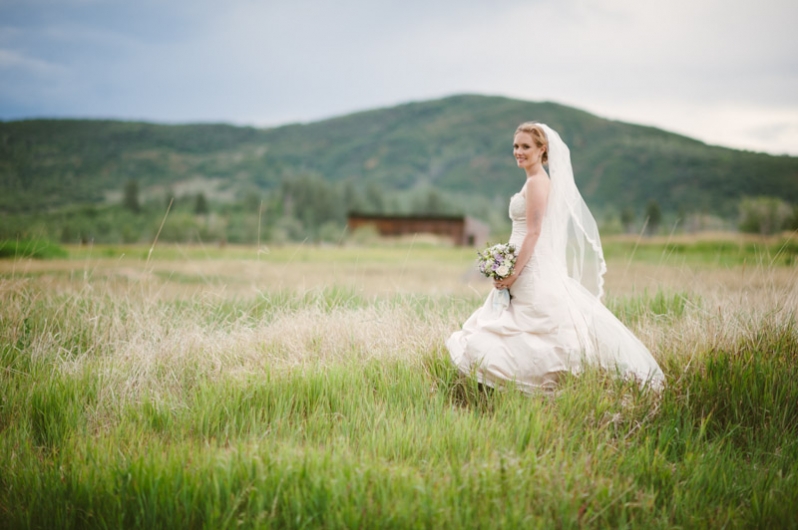 Bride in field and mountain landscape; Steamboat Springs